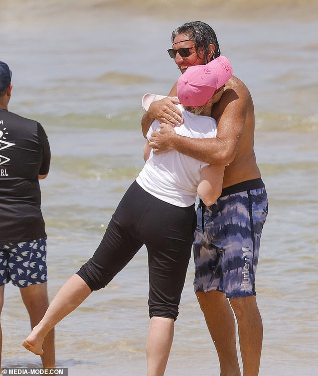 The happy couple looked smitten as they embraced in the surf