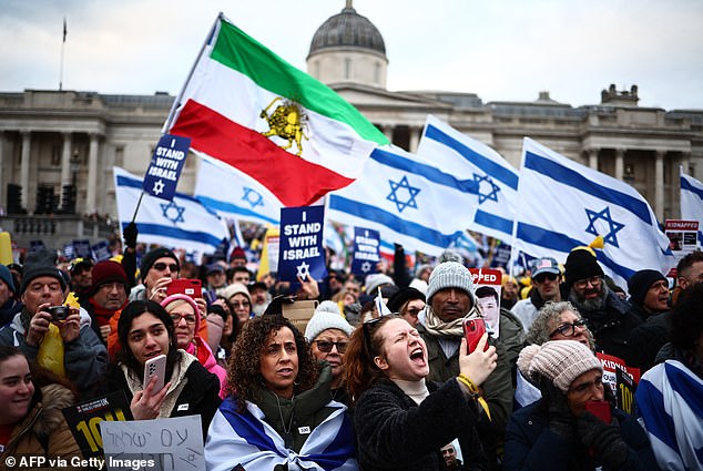 Pro-Israel supporters wave pre-revolution Israeli and Iranian flags as they gather for a demonstration in Trafalgar Square in central London on January 14, 2024