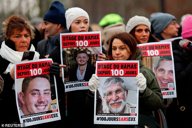 People hold posters depicting Israeli hostages in Gaza during the event "100 days 100 votes" marking 100 days since the October 7 Hamas attack, calling for their release, in front of the Opera Bastille in Paris, France, January 14, 2024