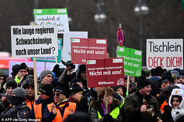 Protesters hold up signs during a protest by farmers and truck drivers in Berlin, Germany on January 15, 2024