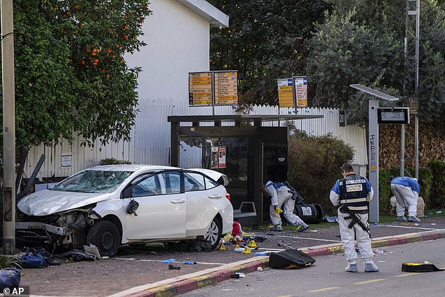 Israeli security forces work the scene of a Palestinian car ramming and stabbing at a bus stop in Ra'anana, Israel