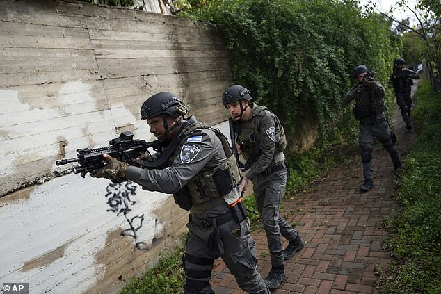 Israeli security forces search for attackers near the scene of a deadly car ramming and stabbing attack at a bus stop in Ra'anana, Israel