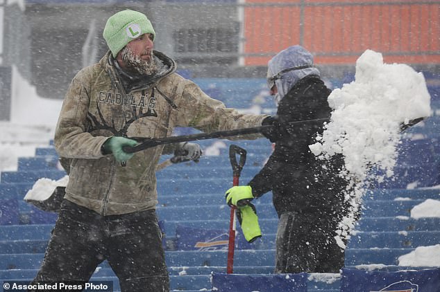 Workers rush to clear snow from Highmark Stadium in Orchard Park before kickoff