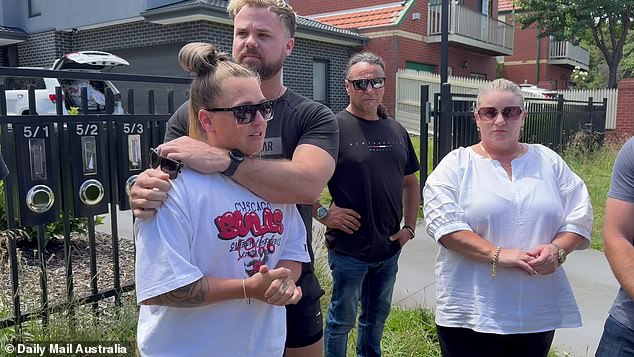 Dr.  Ash Gordon's roommate Tristen Standing (left) comforted the late man's sister, Natalie Gordon (left), as she spoke to reporters on Monday, along with her sister Tammy Gordon (right) and George Charalambous (center)