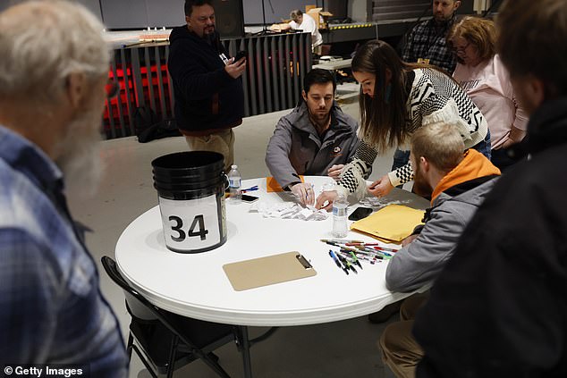 Workers count votes during a caucus at Franklin Junior High on January 15, 2024 in Des Moines, Iowa