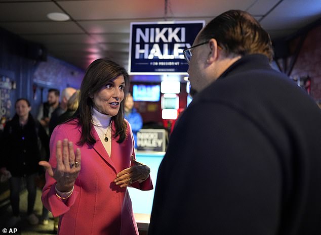 The former South Carolina governor speaks with supporter Chris Varney during a campaign stop earlier in the day at PB's Pub in Newton, Iowa