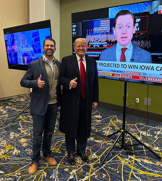 The former president, 77, gives a thumbs up with son Don Jr.  next to a TV screen showing Fox News showing he will win the race