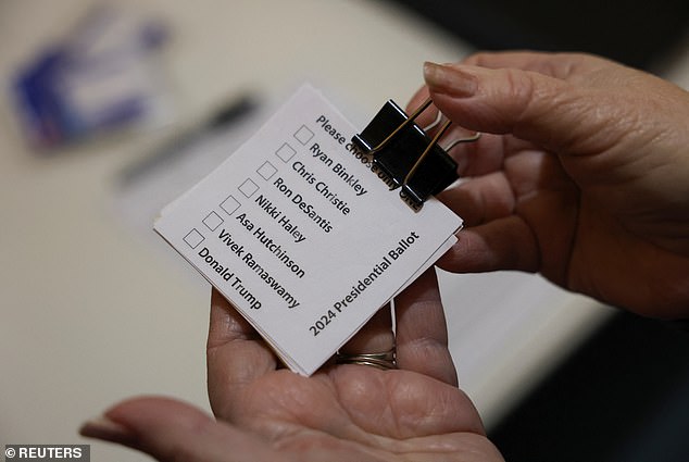 Sharon McNutt holds paper ballots with the names of the candidates in alphabetical order