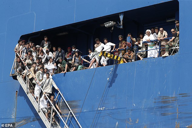 People wait for boats to take them away after touring the deck of the Galaxy Leader freighter