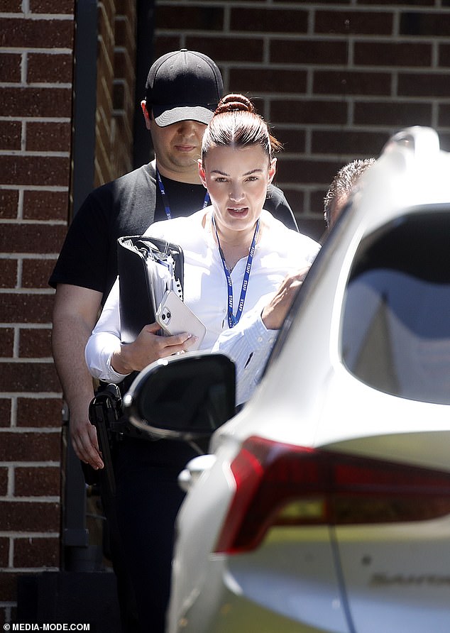 A female detective is seen outside the home during Tuesday's raid