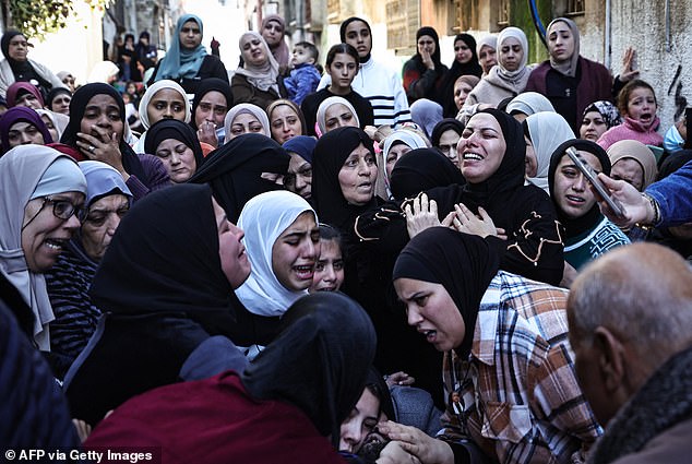 Mourners react around the body of Faris Khalifa during his funeral at the Nur Shams camp for Palestinian refugees in the occupied West Bank on January 16