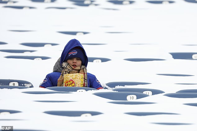 A Buffalo Bills fan sits among snow-covered seats as he awaits the start of an NFL wild-card playoff football game between the Buffalo Bills and the Pittsburgh Steelers, Monday