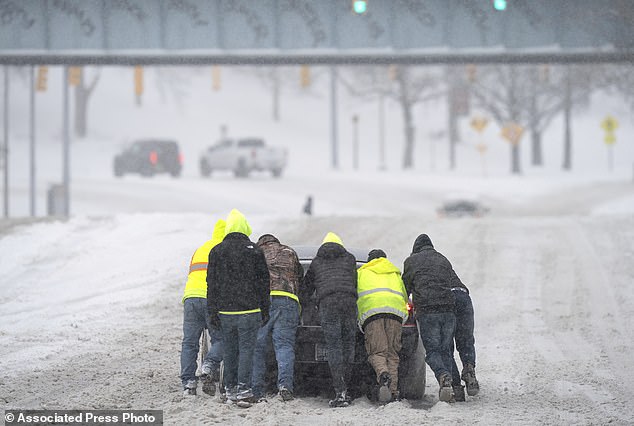 Good Samaritans assist a driver after his rear-wheel drive vehicle became stranded on Rosa L. Parks Blvd.  after a winter storm in Nashville, Tennessee on Monday