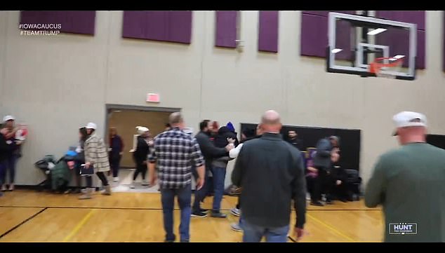 Other caucusgoers quickly responded to the situation and escorted the heckler out