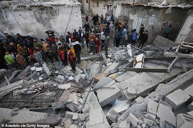 A view of the destroyed home of the Palestinian al-Huli family due to the Israeli attack as civilians inspect the damage in Deir al-Balah, Gaza, on January 16, 2024