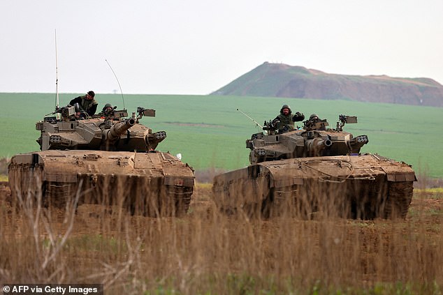 Israeli main battle tanks roll into a position along the Gaza Strip border in southern Israel on January 17, 2024