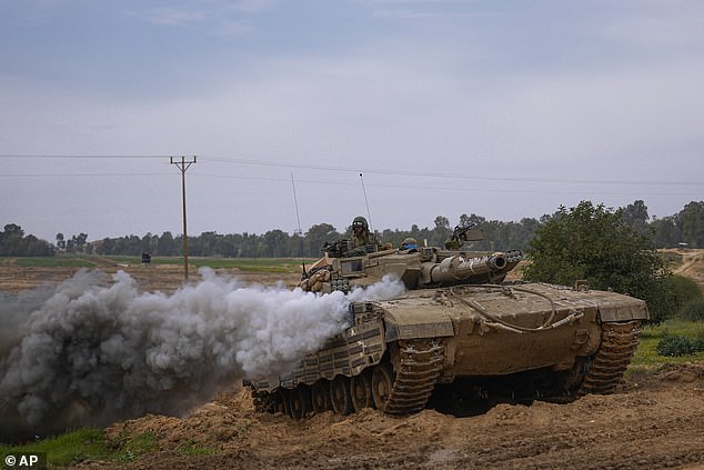 An Israeli army tank approaches the Israel-Gaza border in southern Israel on Wednesday