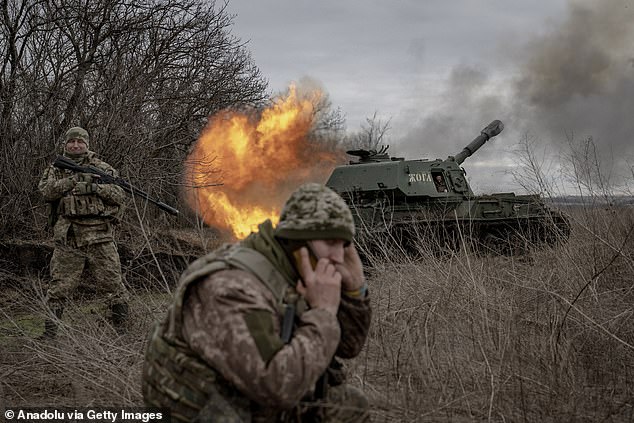 A Ukrainian soldier fires at the Russian position while the Ukrainian soldiers of the artillery unit wait for ammunition assistance on the front line in the direction of Avdiivka on December 28