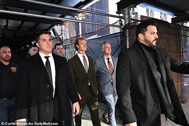 Penny and his lawyers, flanked by security guards, leave court on Wednesday