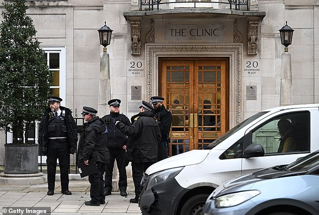 Police officers at the London Clinic today after Kate underwent surgery there yesterday