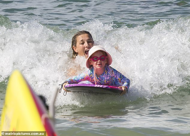 Jasmine was seen gently introducing her daughter to the shallow water and helping the youngster paddle her small boogie board