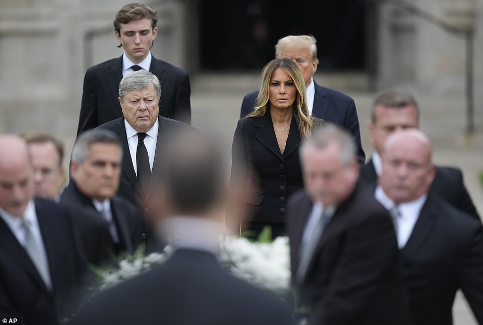 Melania maintained her steely composure as she emerged from the church and watched silently as the coffin was carried out, flanked by pallbearers and clergy.