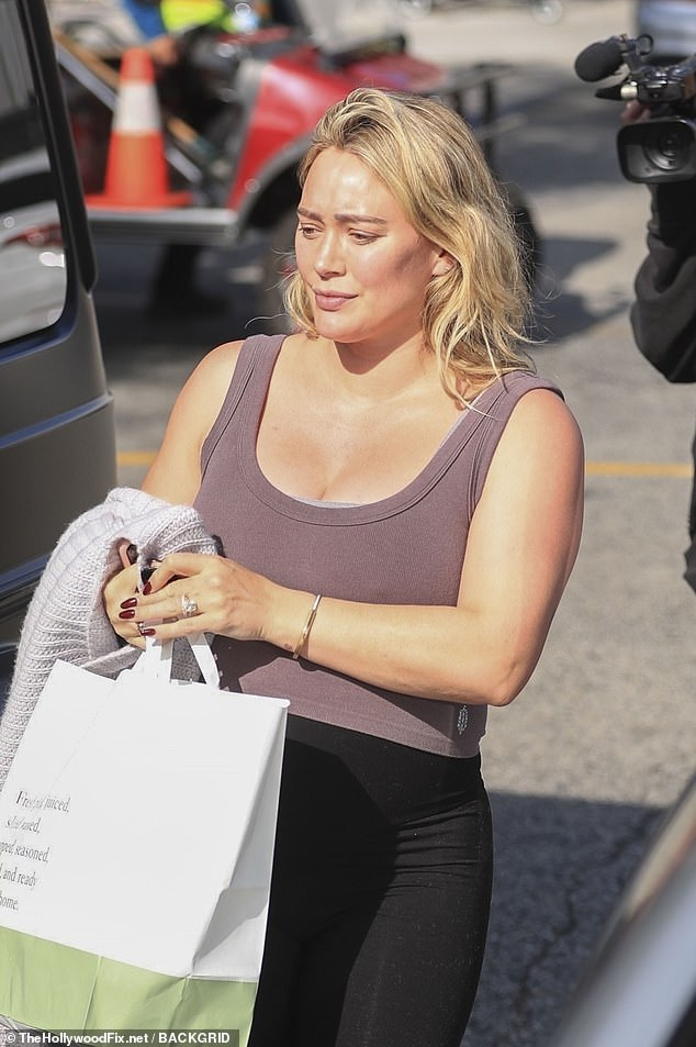 The current mother of three showed off her growing baby bump in high-waisted black leggings and a taupe tank top