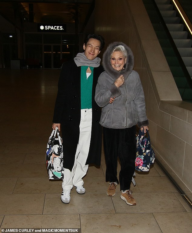 Meanwhile, Carlos Gu linked arms with Angela Rippon as the duo flashed very happy grins through their lenses