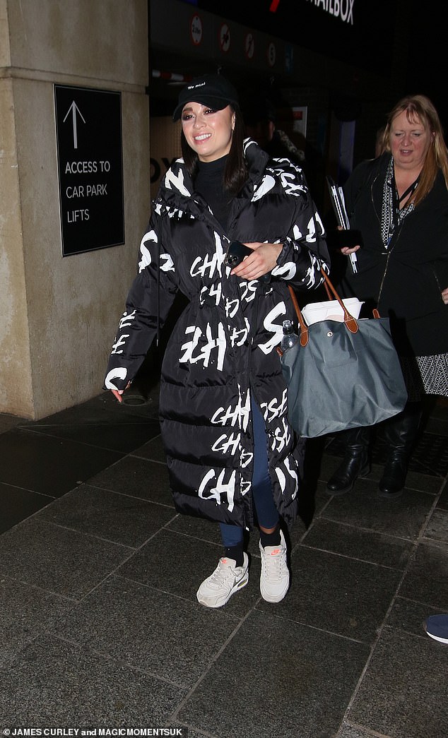 Katya Jones, 34, exuded fashion in a black print maxi puff coat, which she paired with a black turtleneck and a black baseball cap