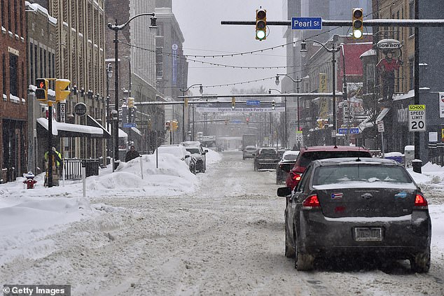 : Vehicles attempt to navigate the snow-covered streets of Buffalo, New York on Thursday