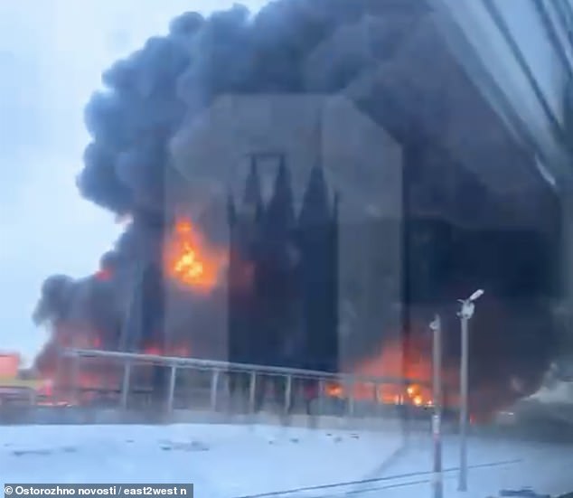 The flames climbing above the Klintsy oil depot can be seen from a passing train