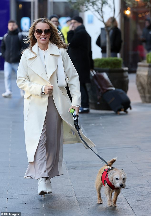 Meanwhile, Amanda, 52, cut an elegant figure in a cream ensemble as she walked her Jack Russell/Yorkshire Terrier cross dog named Rudie on her way out