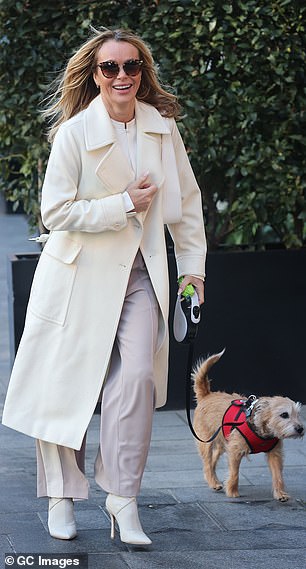 The BGT judge exuded chic in a cream coat, layered with a white blouse and wide-leg trousers