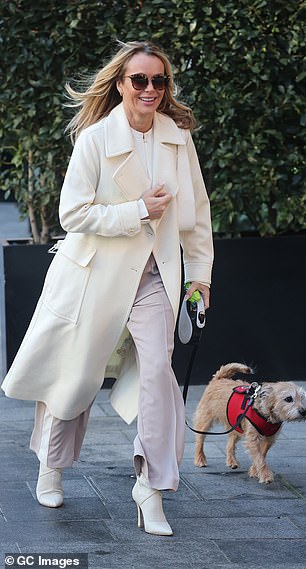 She added a glamorous touch with white heeled boots, paired with a handbag in the same shade