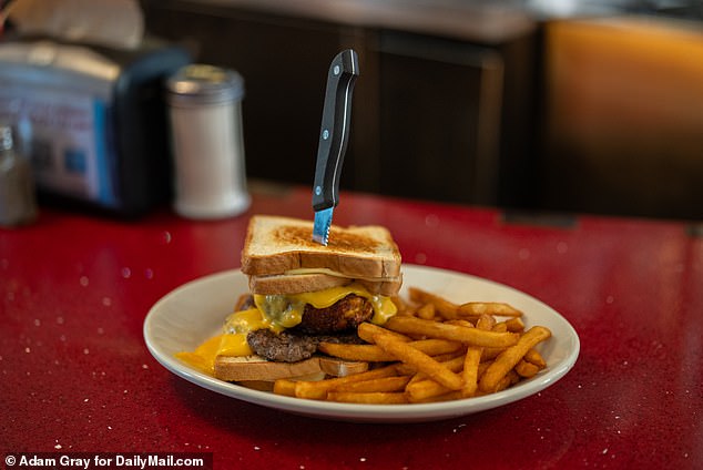 The Trump Tower Burger is a seven-ounce beef patty, with a mac and cheese ball, plus two grilled cheese sandwiches, all dripping with extra cheese sauce