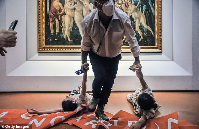 Pictured: A guard drags protesters away from the painting in July 2022