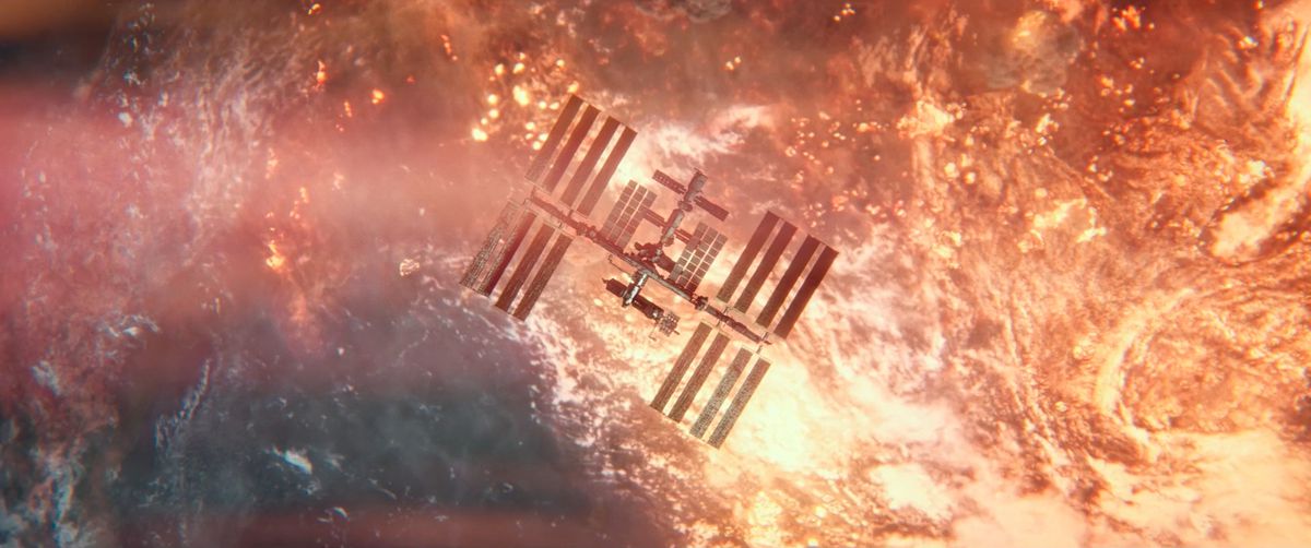 The International Space Station floats in orbit, silhouetted against the burning, vibrant orange post-nuclear war Earth on the ISS