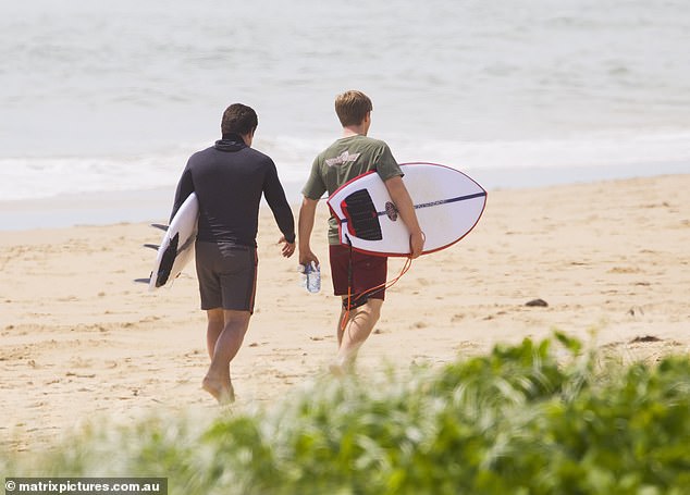 Chandler, 27, wore a black rashie and board shorts, Robert opted for a khaki T-shirt and dark red shorts as they walked on the hot sand on a Sunshine Coast beach