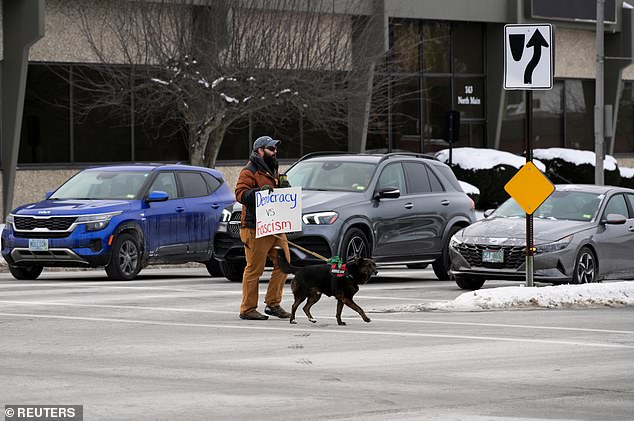 Curtis Register and his dog, Lord Remington of Durham, promote Biden's write-in campaign in Concord, NH