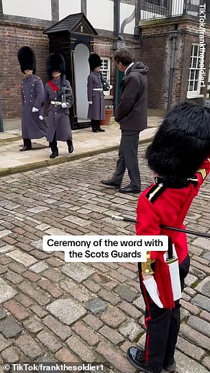 Frank stands to attention as the guards walk by