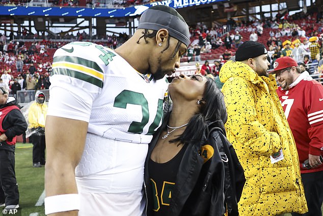 Jonathan Owens of the Green Bay Packers kisses his wife Simone Biles before the game