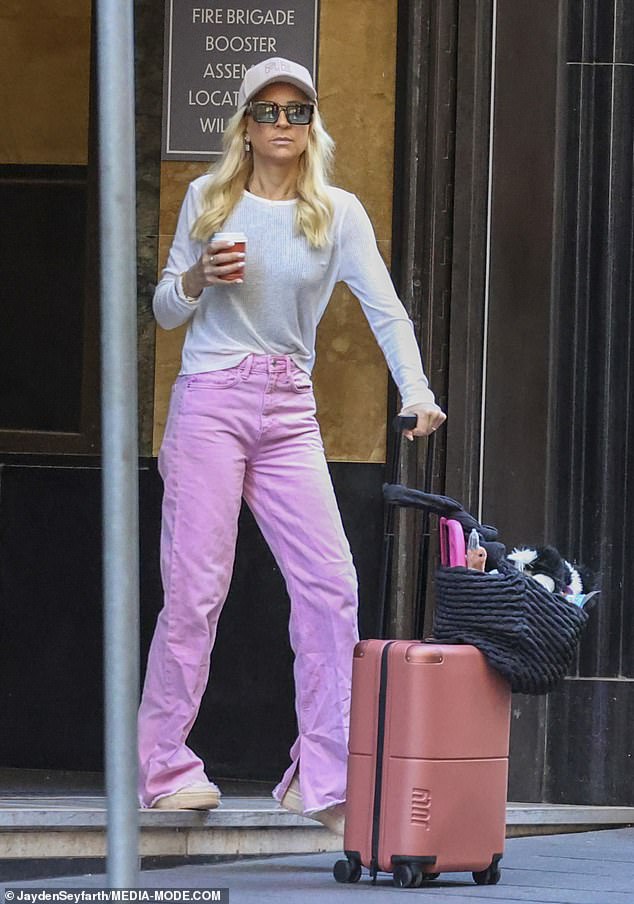 Carrie, 43, looked pretty in pink and stepped out in loose pastel jeans with a white top down the front.