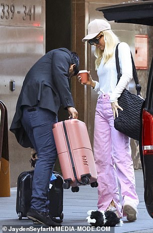 Carrie, who was with her daughters Evie, nine, and Adelaide, six, pulled it over her shoulder and was more than happy to stand back and let her driver load the back of the car with everyone's suitcases.