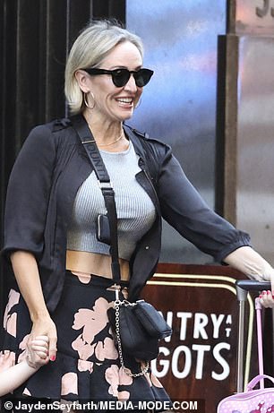 While her little one didn't look particularly happy to be leaving, Fifi smiled as she slung her black designer bag over her body and donned some dark shades.