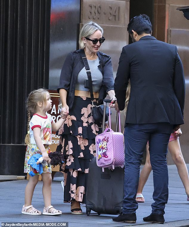 She greeted the driver kindly and handed over her daughter's bright pink Daisy Duck and Minnie Mouse suitcase before getting her into the car.