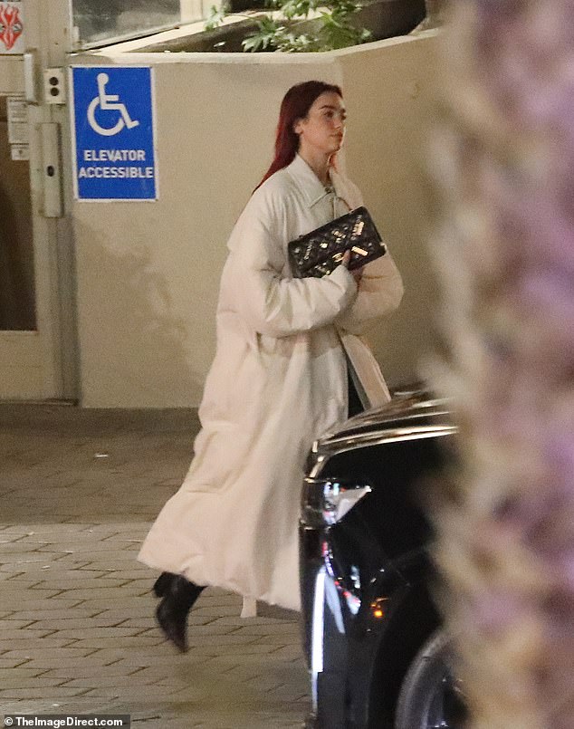 The Dance the Night singer, 28, wore her red hair slicked back and down her back as she clutched her jacket