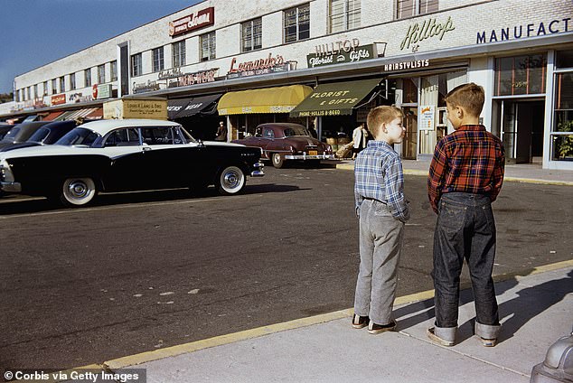 Comic strip centers first emerged in the years after World War II, with the expansion of suburban living and the automobile.  The photo shows two boys standing next to an old-fashioned strip mall parking lot