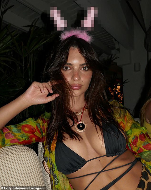 For another colorful look, she wore a black bikini top with long straps around her waist.  As a bikini cover-up, she modeled a sheer green blouse covered in images of fruits and vegetables.  She appeared to be enjoying a late night meal with her friends, as seen in a photo of her wearing a pink, fluffy and phallic headband