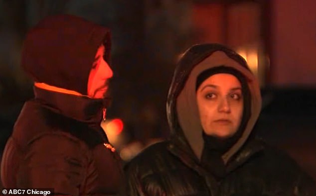 Two local residents are seen at the scene on Sunday evening while the police are still present