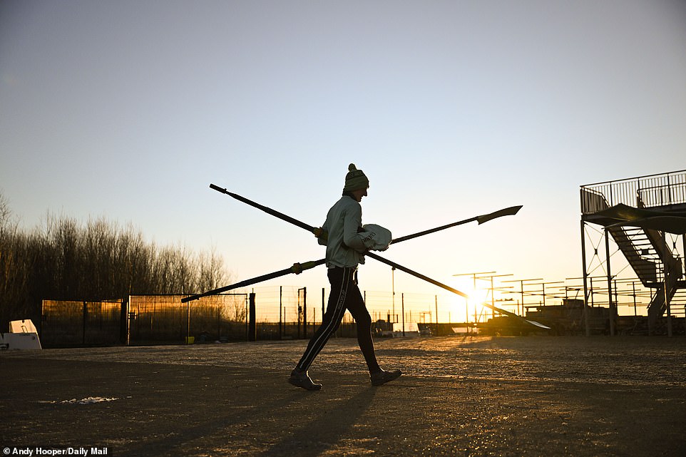 We see one of the crew members, with two oars in hand, preparing the boats for training just after 6am